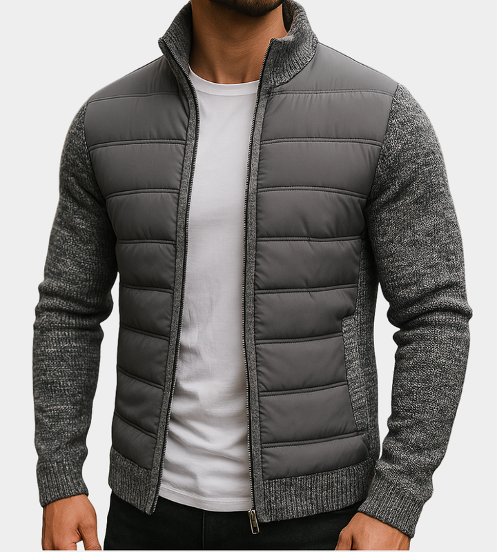 Homme portant la version gris anthracite, buste matelassé et manches en maille chinée, zippée sur un t-shirt blanc. 1