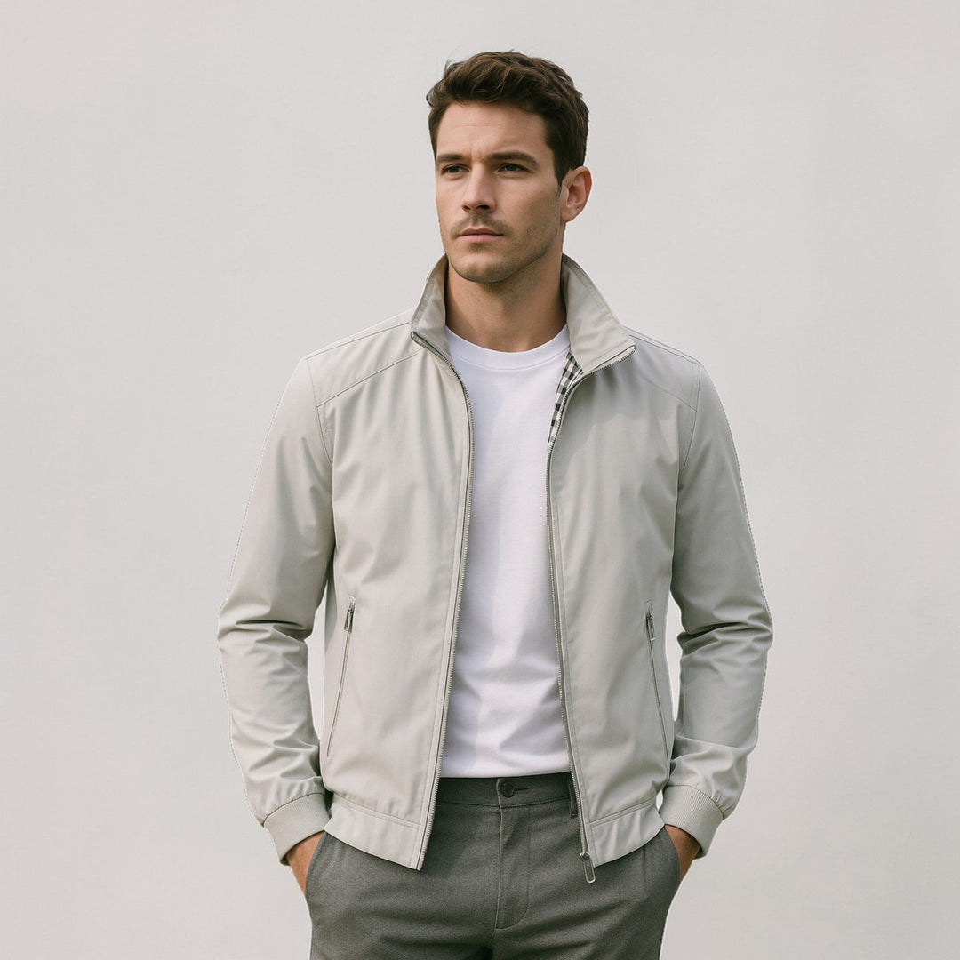 Homme portant la veste gris clair ouverte sur un t-shirt blanc, doublure à carreaux au col, pantalon gris, mains dans les poches. 5