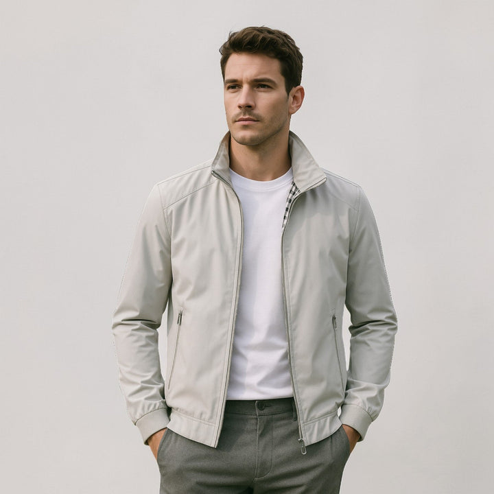 Homme portant la veste gris clair ouverte sur un t-shirt blanc, doublure à carreaux au col, pantalon gris, mains dans les poches. 5