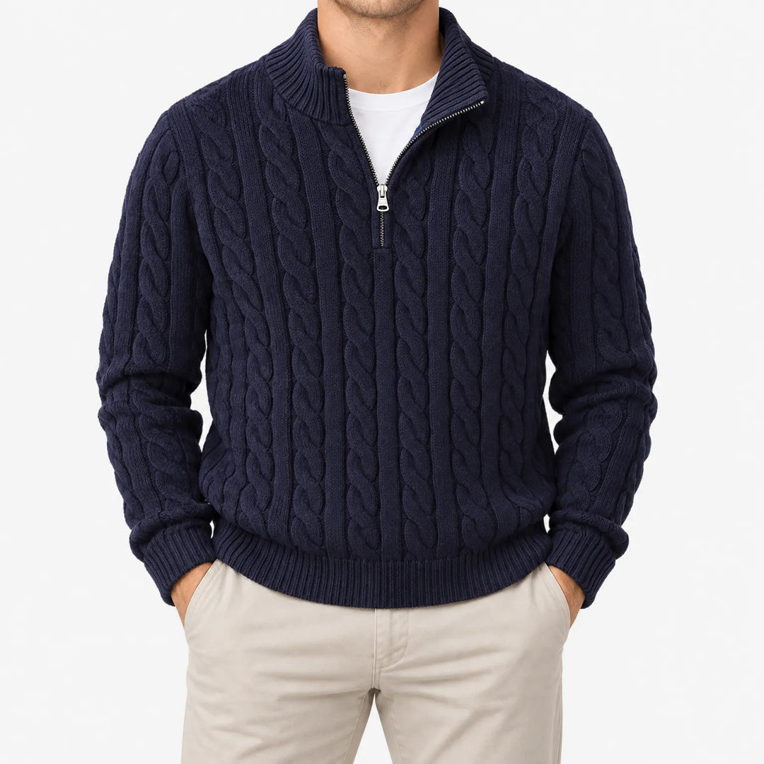 Pull bleu marine à torsades et demi-zip porté avec un pantalon beige, mains dans les poches, vue de face sur fond blanc. 8
