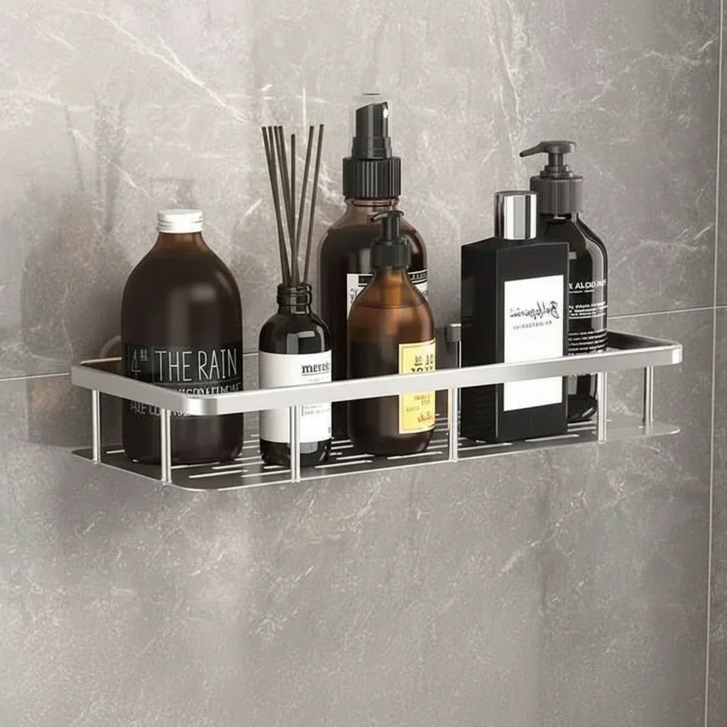 Étagère argentée au fond ajouré, remplie de flacons ambrés et noirs, sur un mur en marbre gris 5