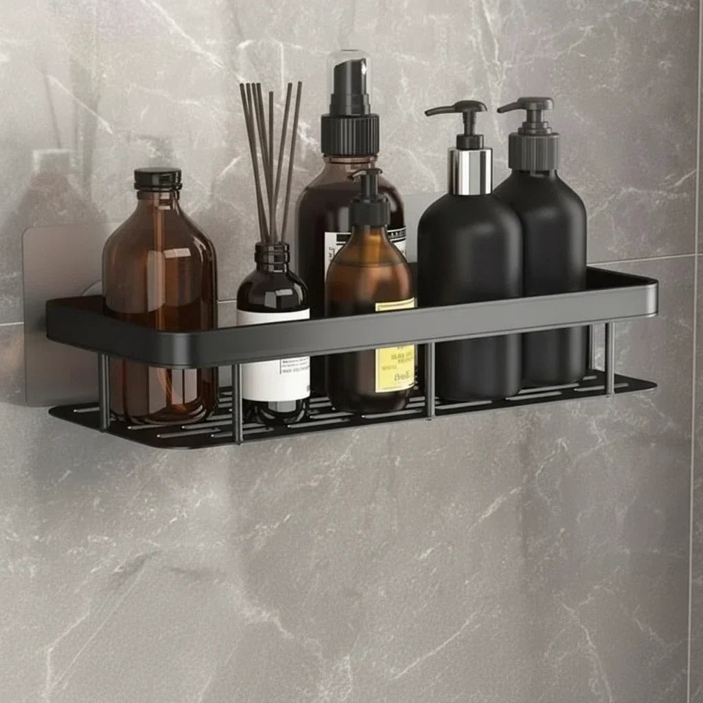 Étagère noire au fond ajouré, chargée de flacons ambrés et de distributeurs noirs sur mur marbré 6