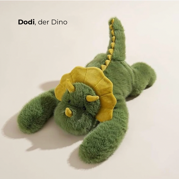 Peluche dinosaure vert à collerette et cornes jaunes, allongé avec la queue dressée, vu de dessus. 4