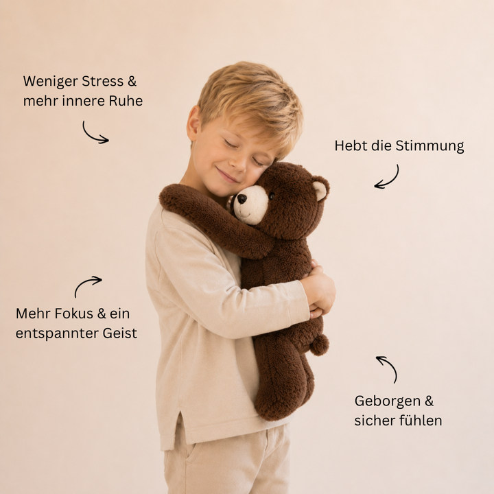 Petit garçon blond souriant, yeux fermés, serrant dans ses bras un ours en peluche brun foncé. 7
