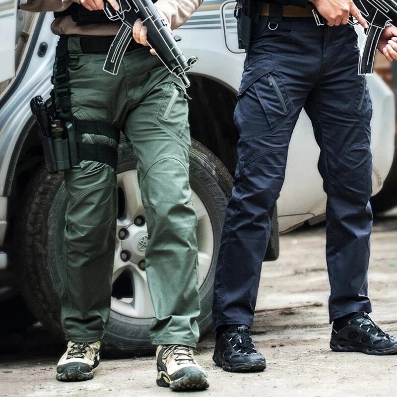 Deux hommes portant ce pantalon tactique, l'un en vert kaki, l'autre en bleu marine, debout devant un véhicule tout-terrain. 2