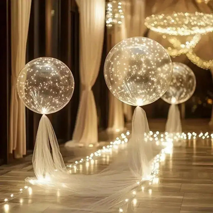 Ballons transparents éclairés, noués de tulle blanc et posés sur un sol brillant, bordé d'une guirlande lumineuse. 6