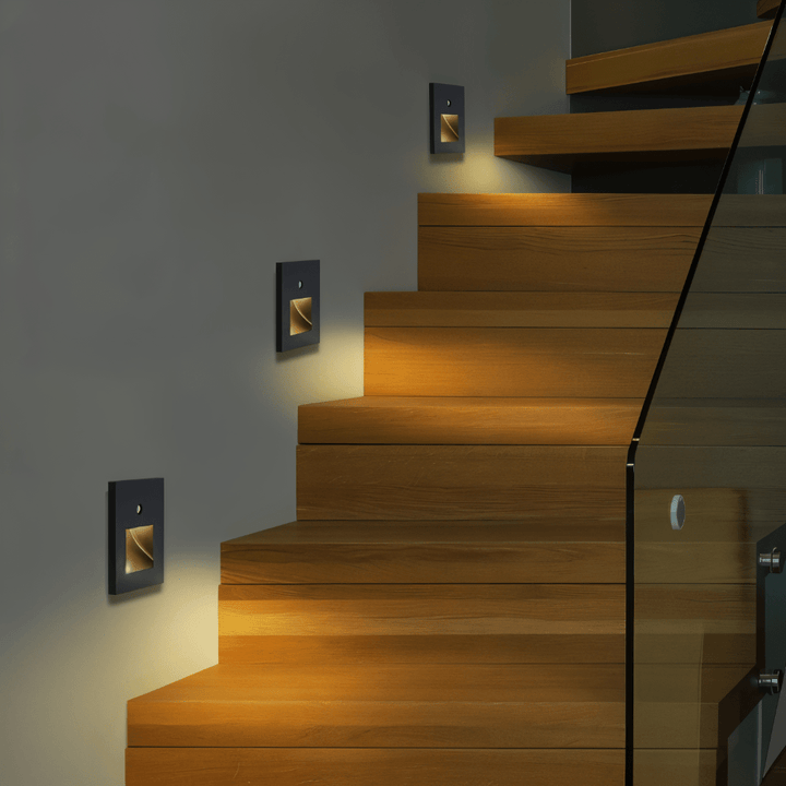 Appliques carrées noires à lumière chaude le long d'un escalier en bois avec garde-corps en verre 3