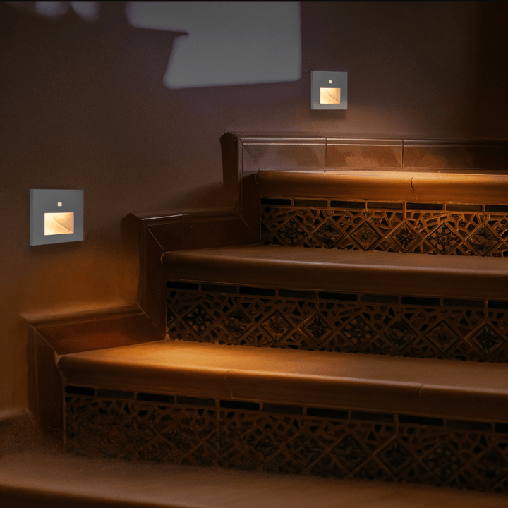 Appliques grises à lumière ambrée sur un escalier carrelé, éclairage doux dans une ambiance sombre 4