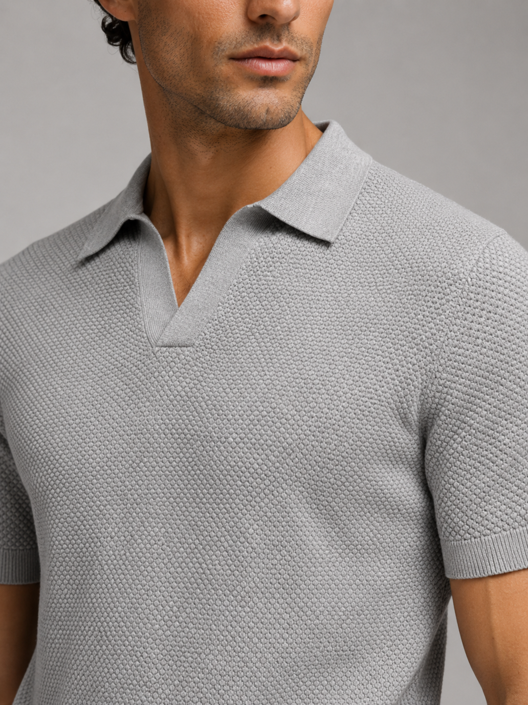 Gros plan sur le col ouvert et le tricot en relief du polo gris 27