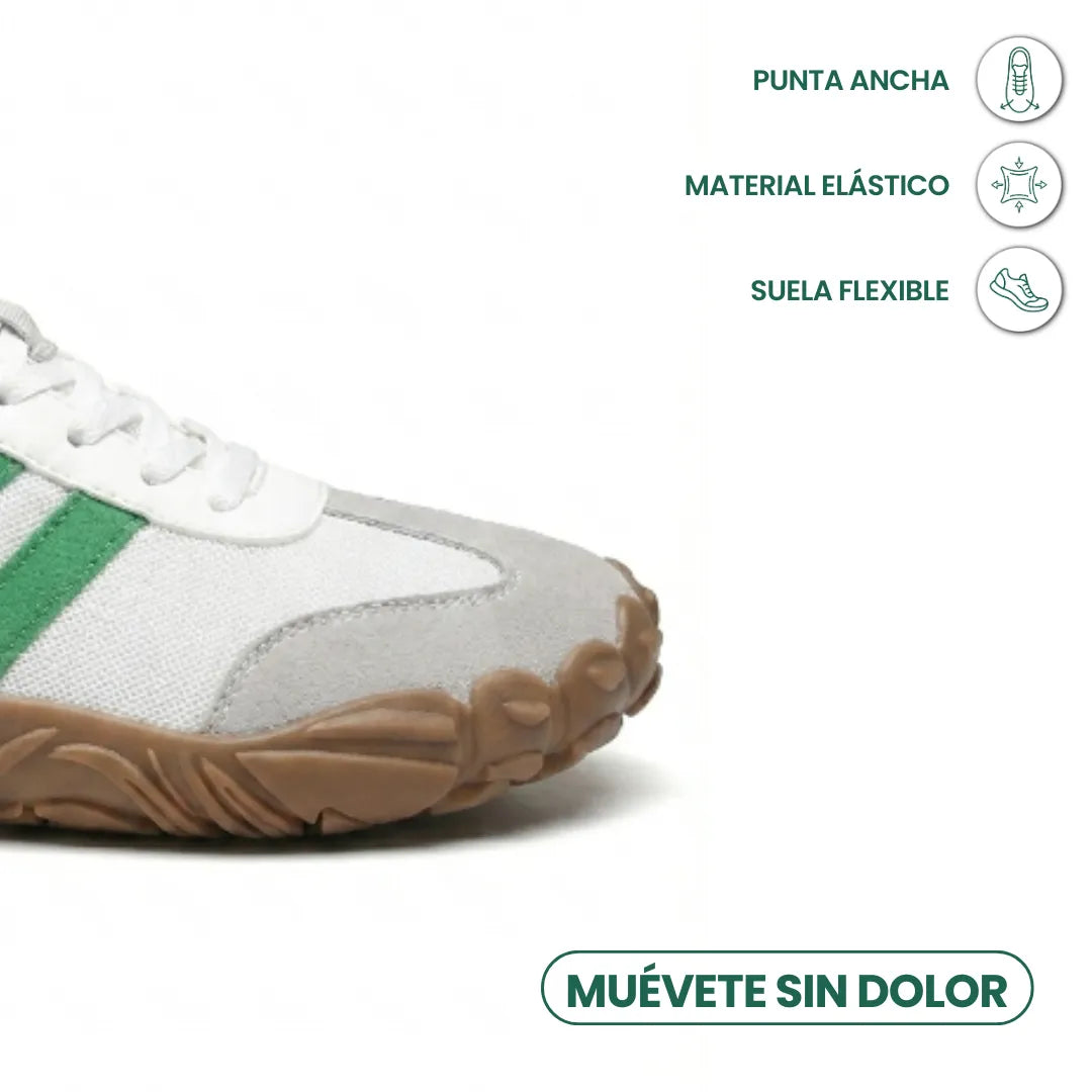 Gros plan sur l'avant de la version blanche et verte, bout large en daim gris, semelle souple, avec icônes confort et flexibilité. 32