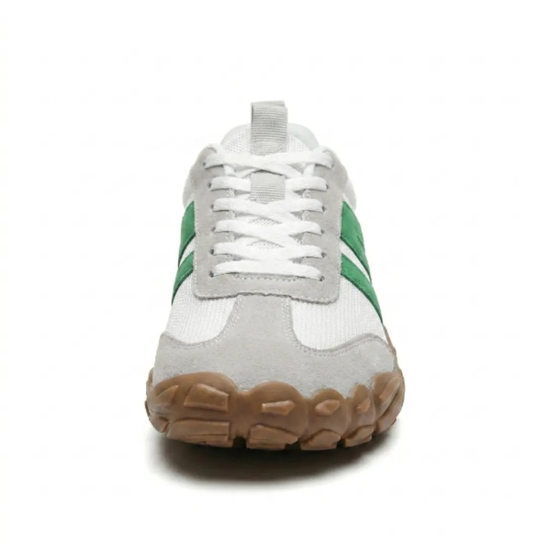 Vue de face d'une chaussure blanche à bandes vertes, avec large bout arrondi en daim gris et semelle gomme marron épaisse. 35