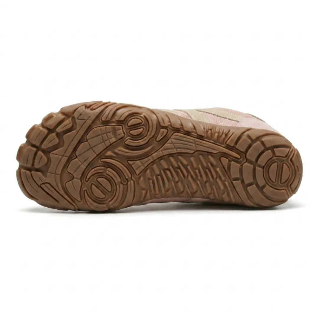 Dessous de la chaussure rose montrant la semelle caramel aux motifs de crampons et de rainures variés. 18