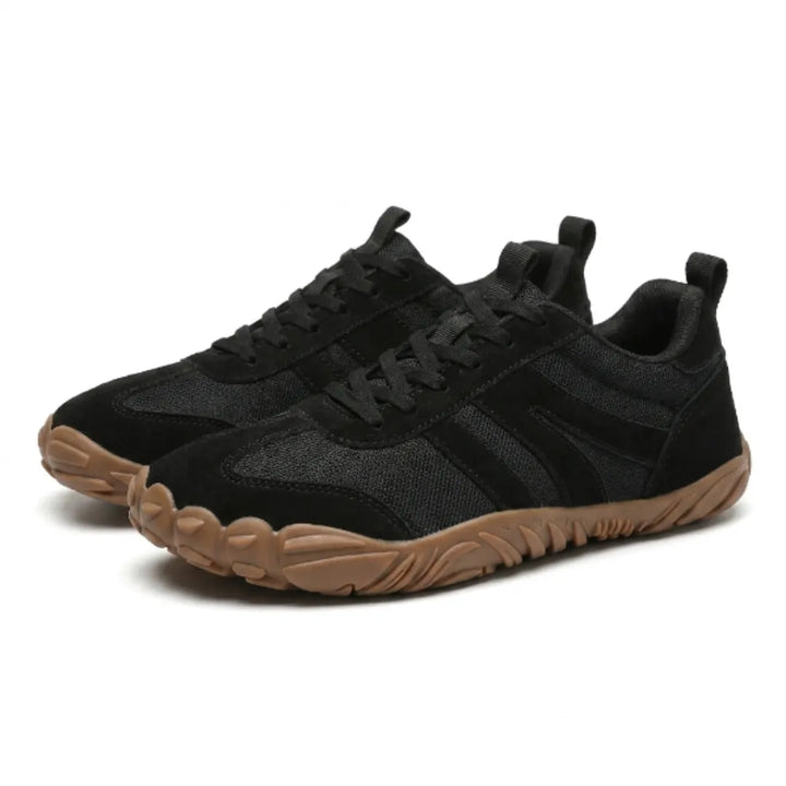 Paire de baskets barefoot noires vue de trois quarts, mesh respirant, bandes en daim, lacets noirs et semelle gomme marron. 25