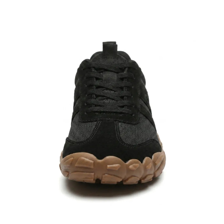 Vue de face d'une chaussure noire à lacets, avec large bout arrondi et semelle gomme marron aux reliefs marqués. 26