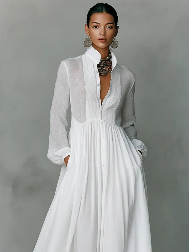 Gros plan sur le buste de la robe blanche : col mao, boutons et plastron plissé 5