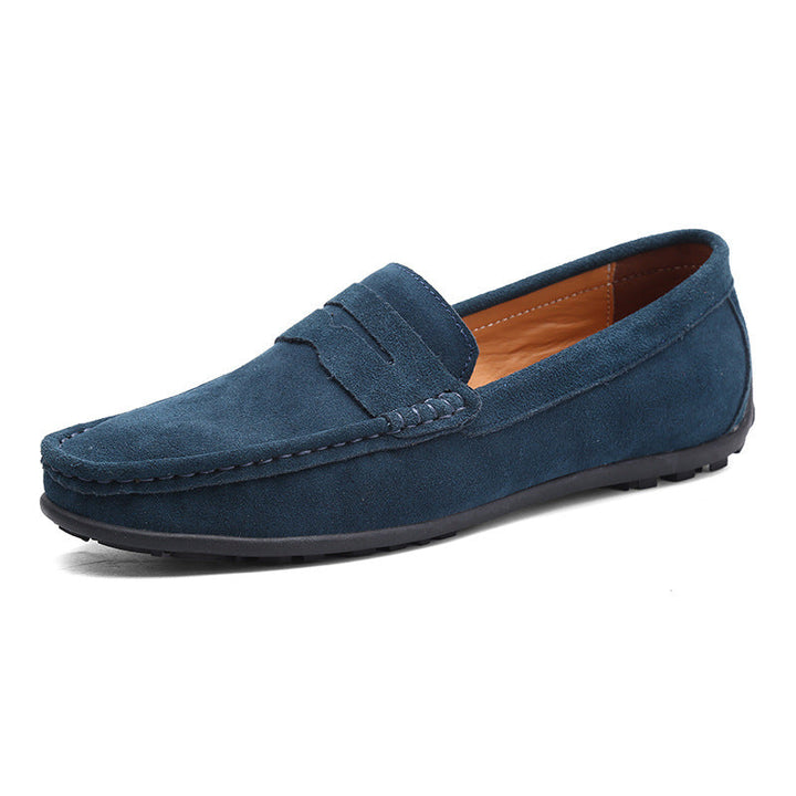 Mocassin penny en daim bleu pétrole, vu de trois quarts, avec bride décorative, doublure en cuir fauve et semelle noire. 2