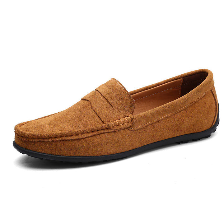 Mocassin penny en daim brun clair, vu de trois quarts, avec surpiqûres apparentes sur l'empeigne et semelle souple noire. 3