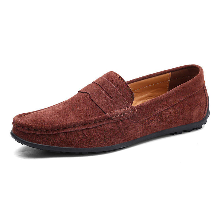 Mocassin penny en daim brun rouge, vu de trois quarts, avec bride sur le dessus, intérieur fauve et semelle noire à picots. 4