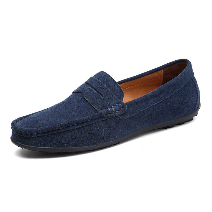 Mocassin penny en daim bleu marine, vu de trois quarts, avec bride sur le dessus, doublure fauve et semelle noire. 7