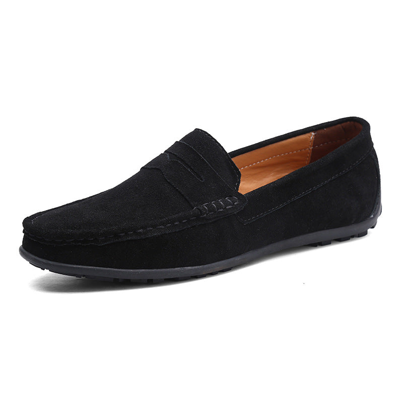 Mocassin penny en daim noir, vu de trois quarts, avec bride sur le cou-de-pied, doublure fauve et semelle gomme noire. 1