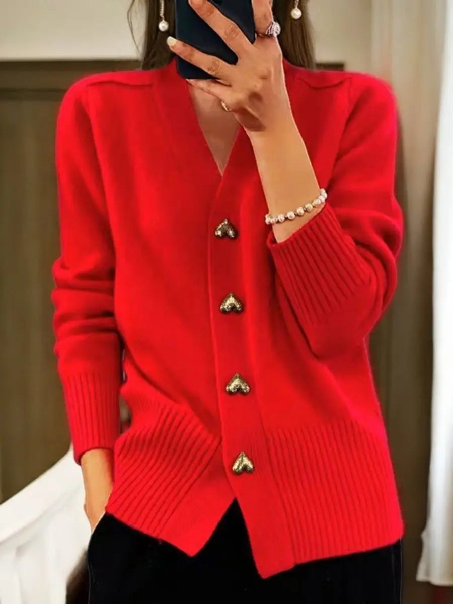 Version rouge vif portée avec un pantalon noir, bracelet de perles au poignet et rangée de quatre boutons cœur dorés. 4