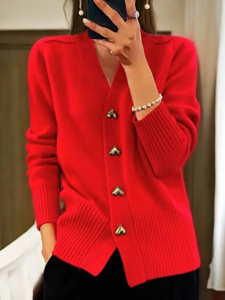 Version rouge vif portée avec un pantalon noir, bracelet de perles au poignet et rangée de quatre boutons cœur dorés. 4