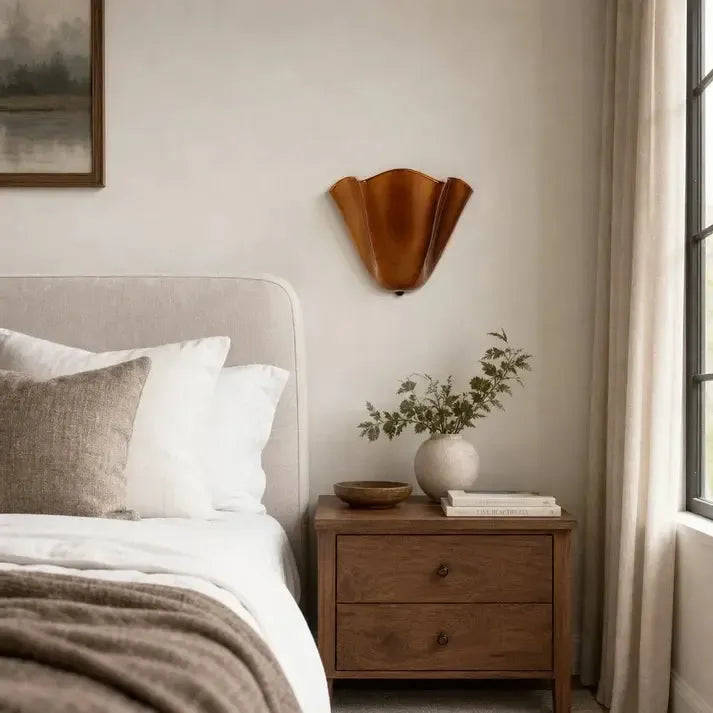 Applique de teinte cuivrée éteinte, fixée au-dessus d'une table de chevet en bois dans une chambre claire près d'une fenêtre. 3