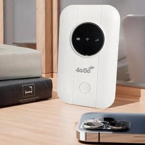 Boîtier blanc posé debout sur une étagère en bois, près de livres et d'un smartphone 3