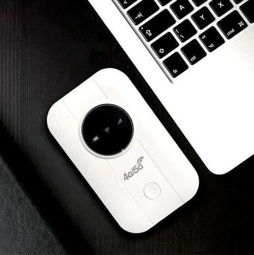 Vue de dessus du boîtier blanc posé sur un bureau noir, à côté d'un clavier 5
