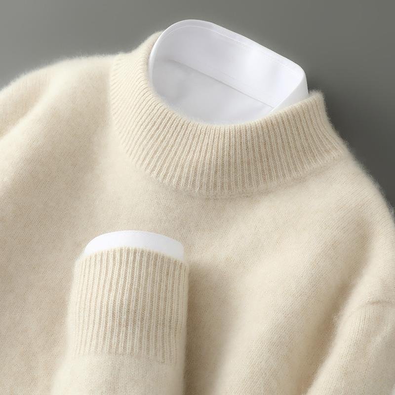 Pull beige crème à col rond côtelé, vu de près, avec col et poignet de chemise blanche qui dépassent. 1