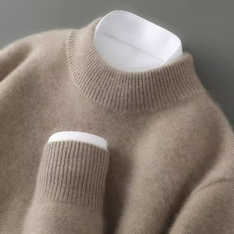 Pull taupe à col rond côtelé en gros plan, un col de chemise blanche sortant de l'encolure et du poignet. 2