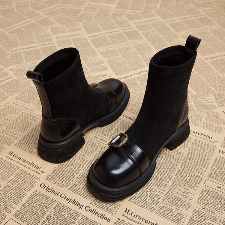 Bottines noires en daim et cuir lisse, boucle dorée sur l'avant-pied, vues de trois quarts avec le talon de la botte de gauche. 4