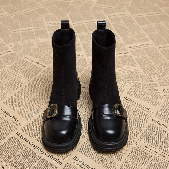 Paire de bottines noires vue de face, tiges en daim souple, bouts carrés en cuir brillant ornés d'une boucle dorée. 5