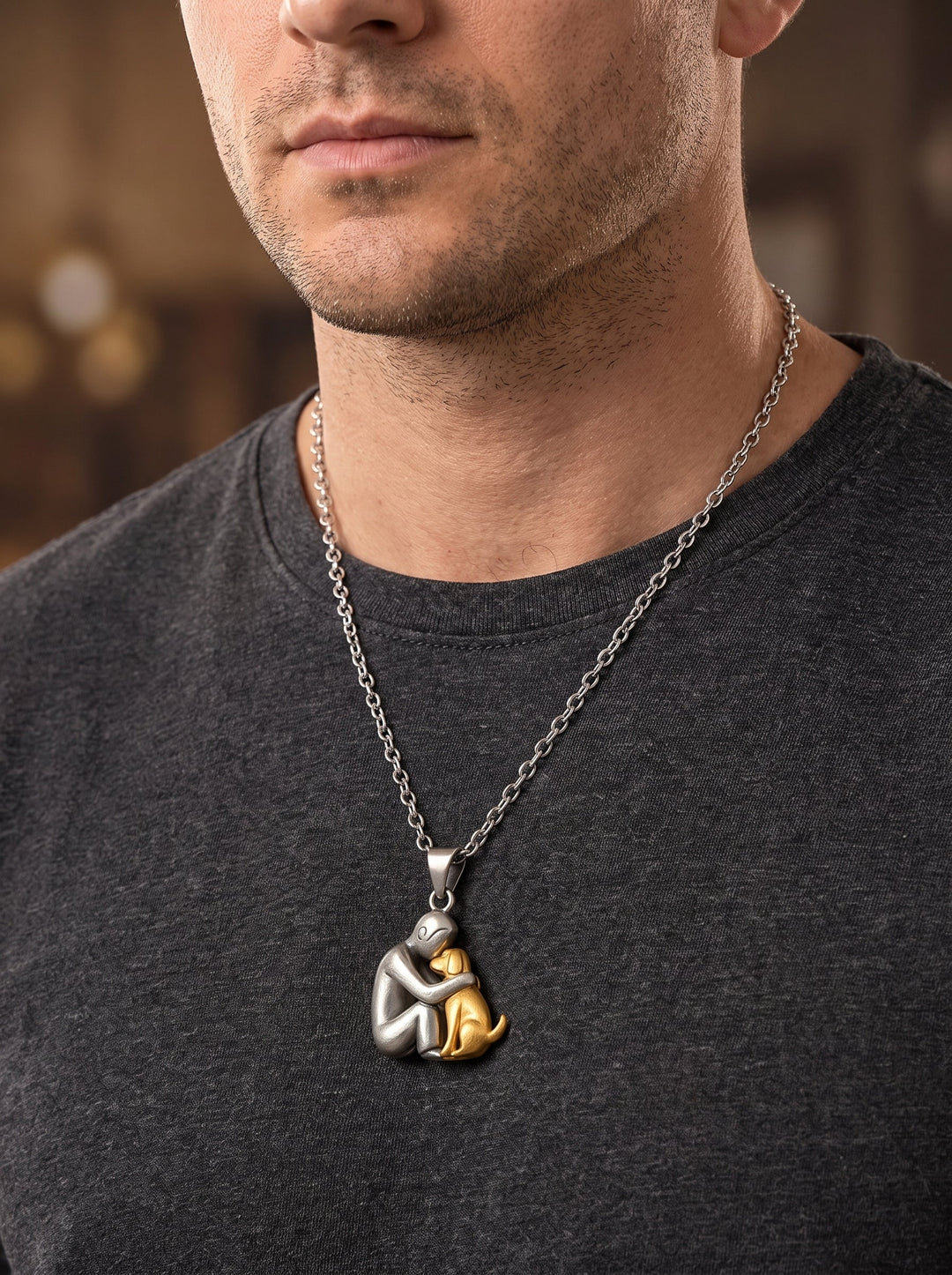 Homme en t-shirt gris anthracite portant le pendentif personne argentée et chien doré sur une chaîne argentée plus longue. 11