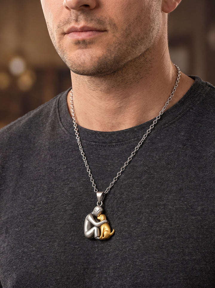 Homme en t-shirt gris anthracite portant le pendentif personne argentée et chien doré sur une chaîne argentée plus longue. 11