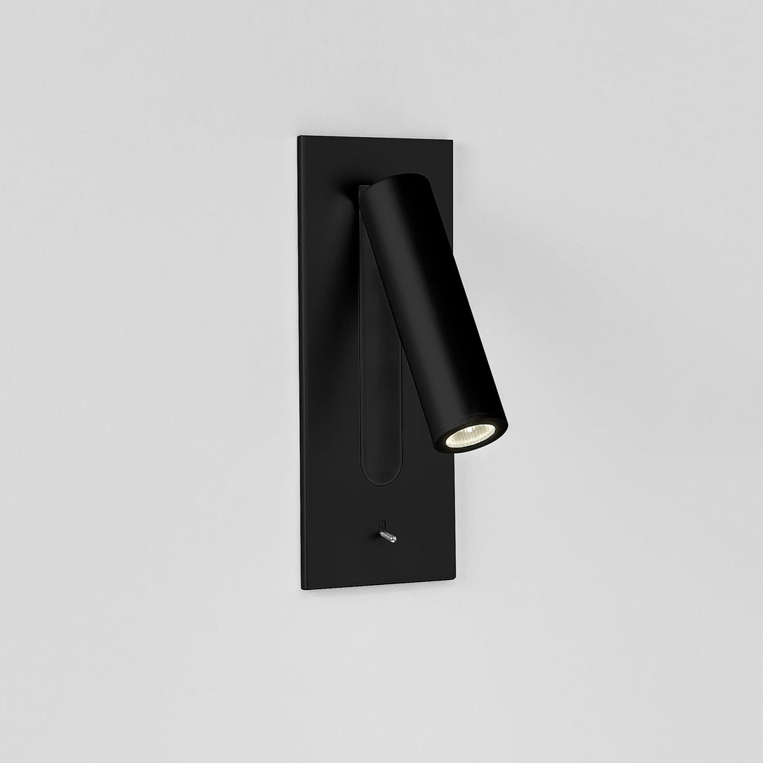 Applique noire mate, tube orienté vers la droite, LED allumée sur mur clair 20