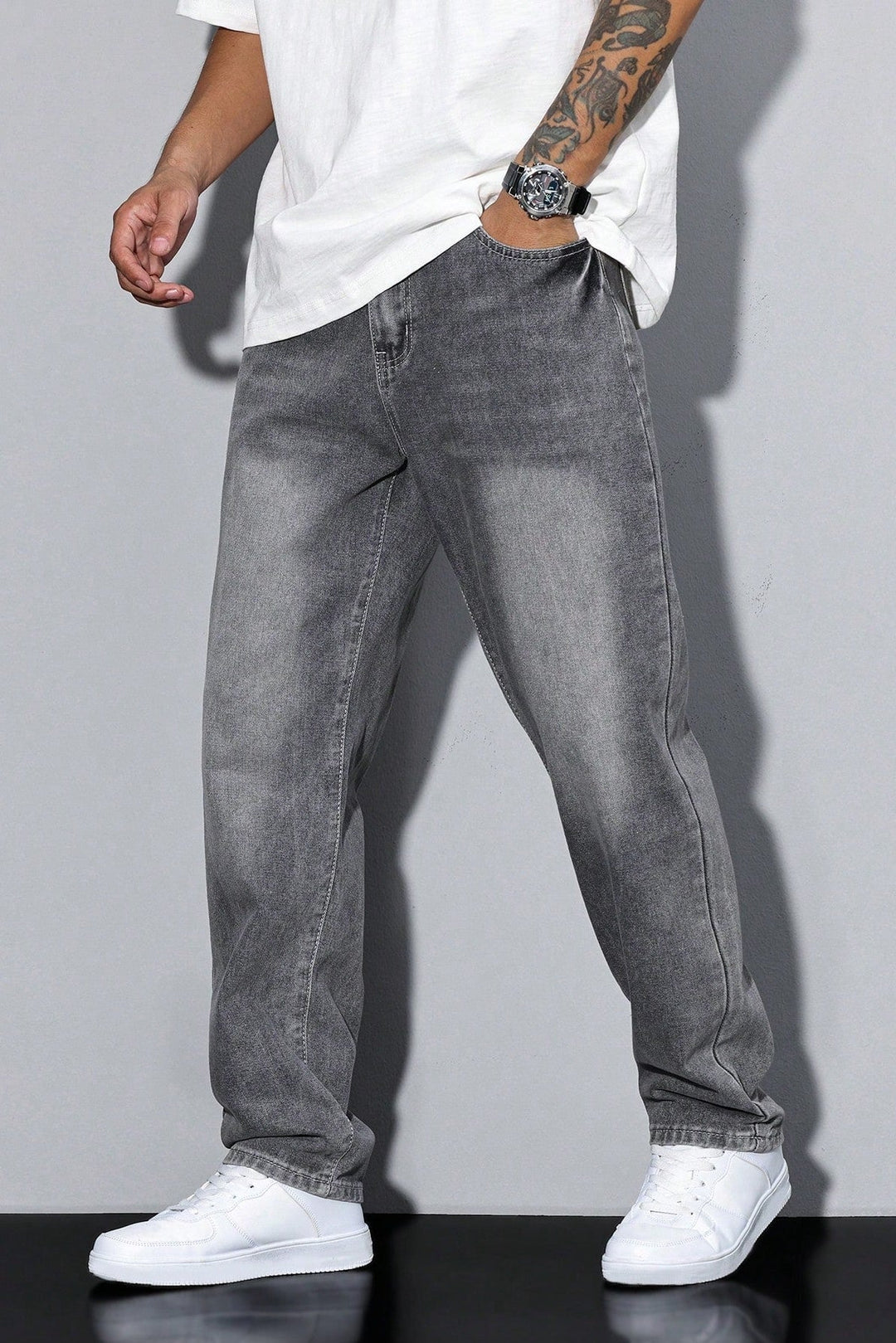 Jean gris clair délavé porté de trois quarts, main dans la poche, avec t-shirt blanc et baskets 5