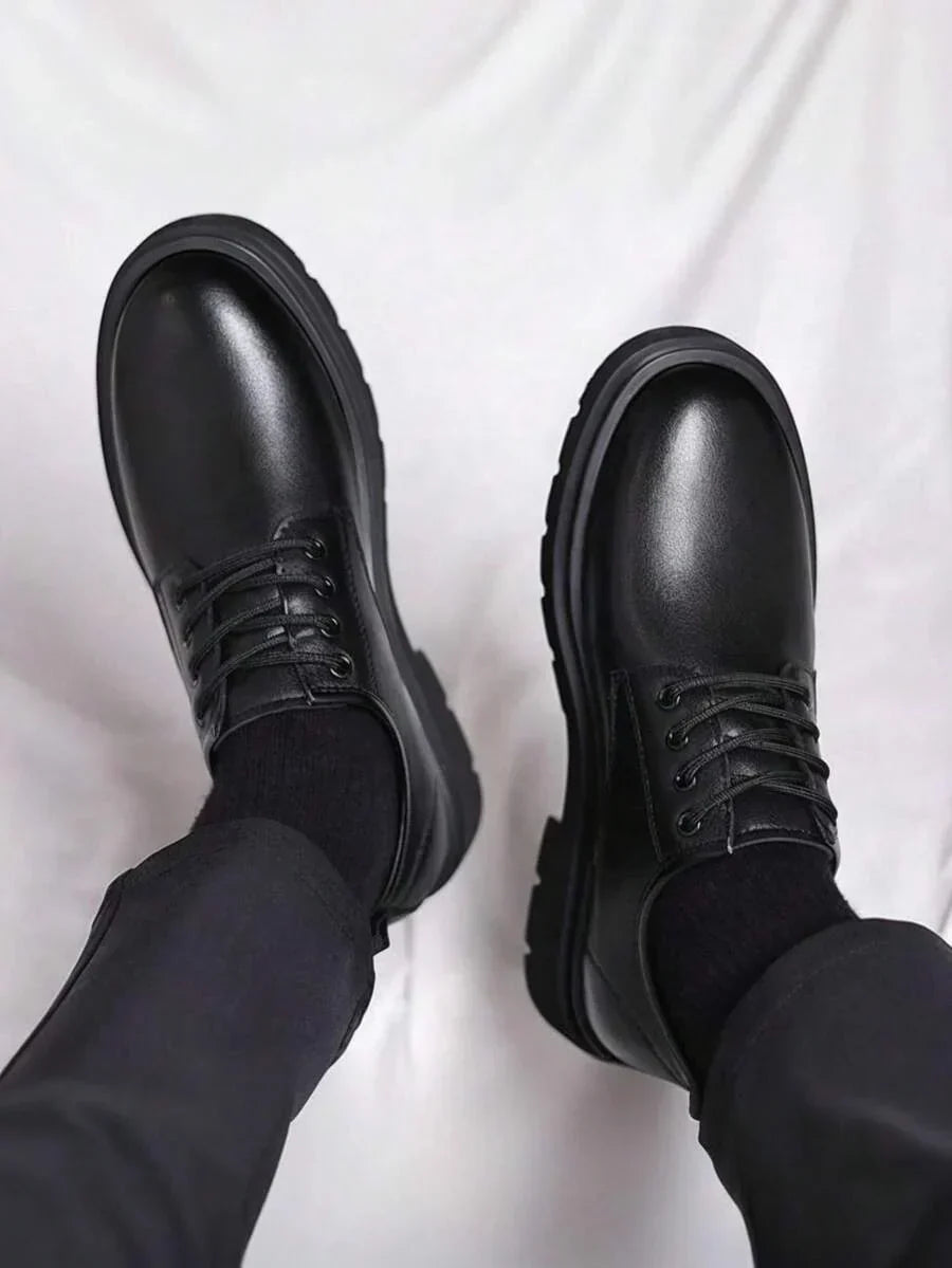 Vue plongeante sur les bouts arrondis brillants des derbies noires portées avec un pantalon sombre 4