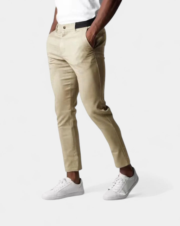 Pantalon beige clair porté par un homme en t-shirt blanc et baskets blanches, mains dans les poches 3