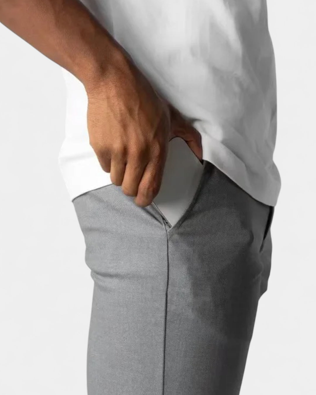 Gros plan sur la poche latérale du pantalon gris, avec une main qui s'y glisse 6