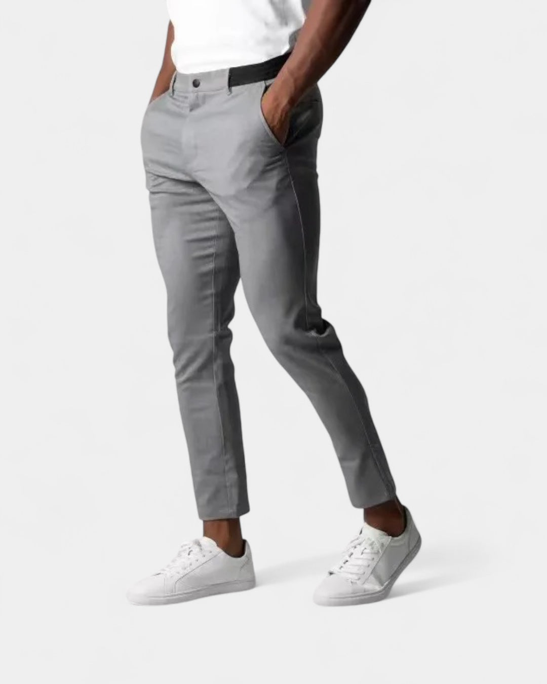 Homme portant le pantalon gris clair avec baskets blanches, une main dans la poche, vue de trois quarts 1