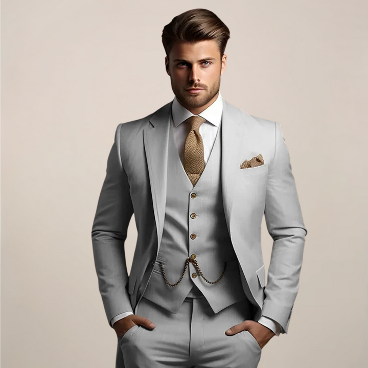 Même costume trois pièces en version gris clair, porté par un mannequin avec gilet à boutons, chaînette dorée, cravate et pochette. 2