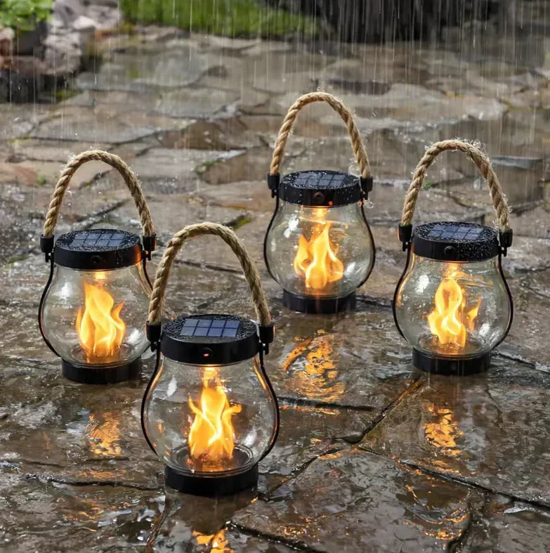Quatre lanternes à flamme allumées sur une terrasse en pierre mouillée sous la pluie 3