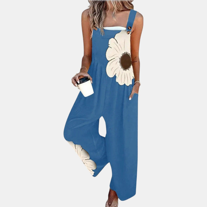 Salopette bleue portée de face avec une grande fleur crème au centre brun sur le buste 6