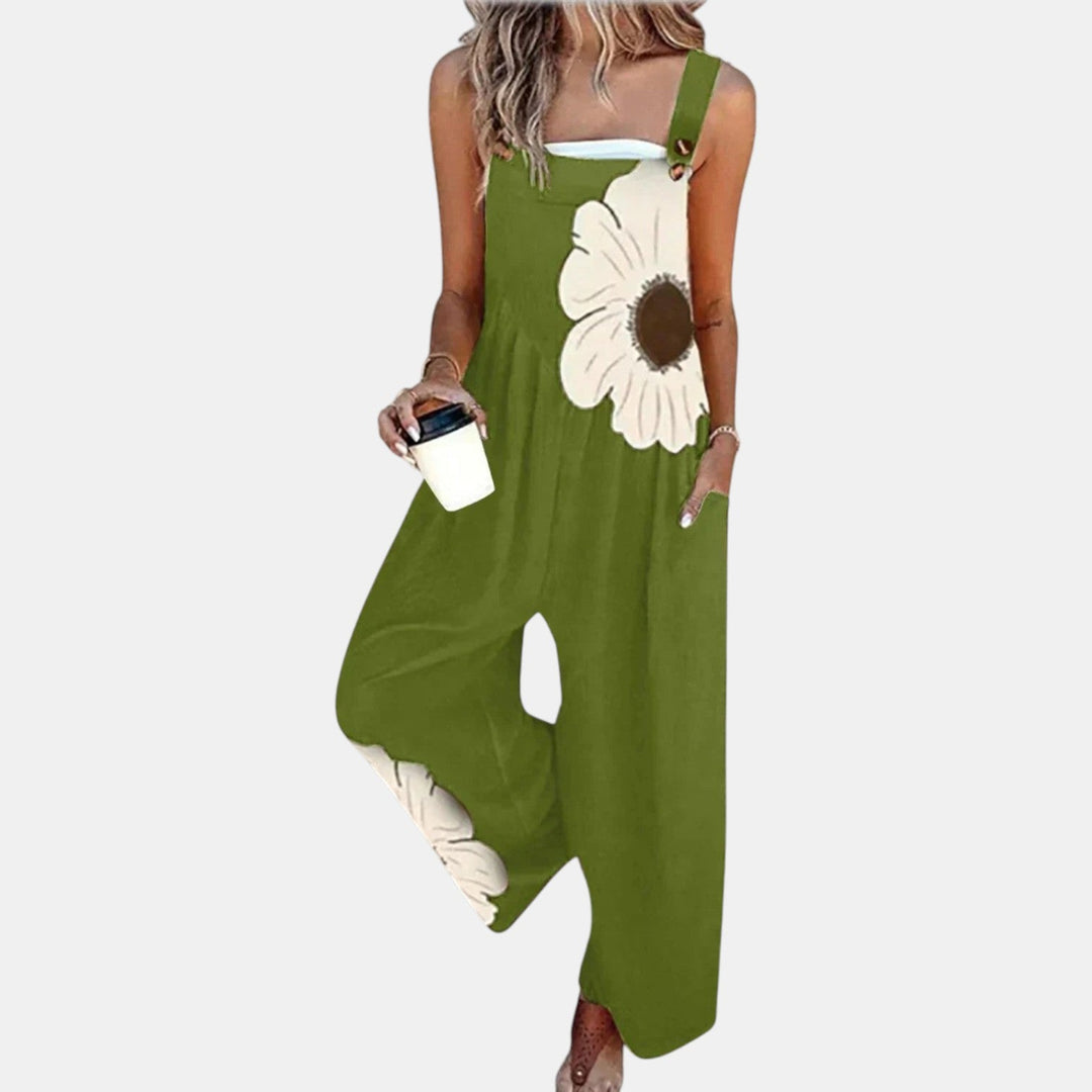 Salopette vert olive portée de face avec une grande fleur crème sur le buste, gobelet à la main 10