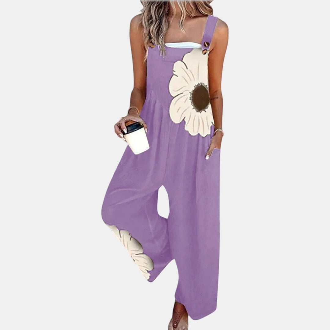 Salopette violet clair portée de face avec une grande fleur crème sur le buste, gobelet à la main 8