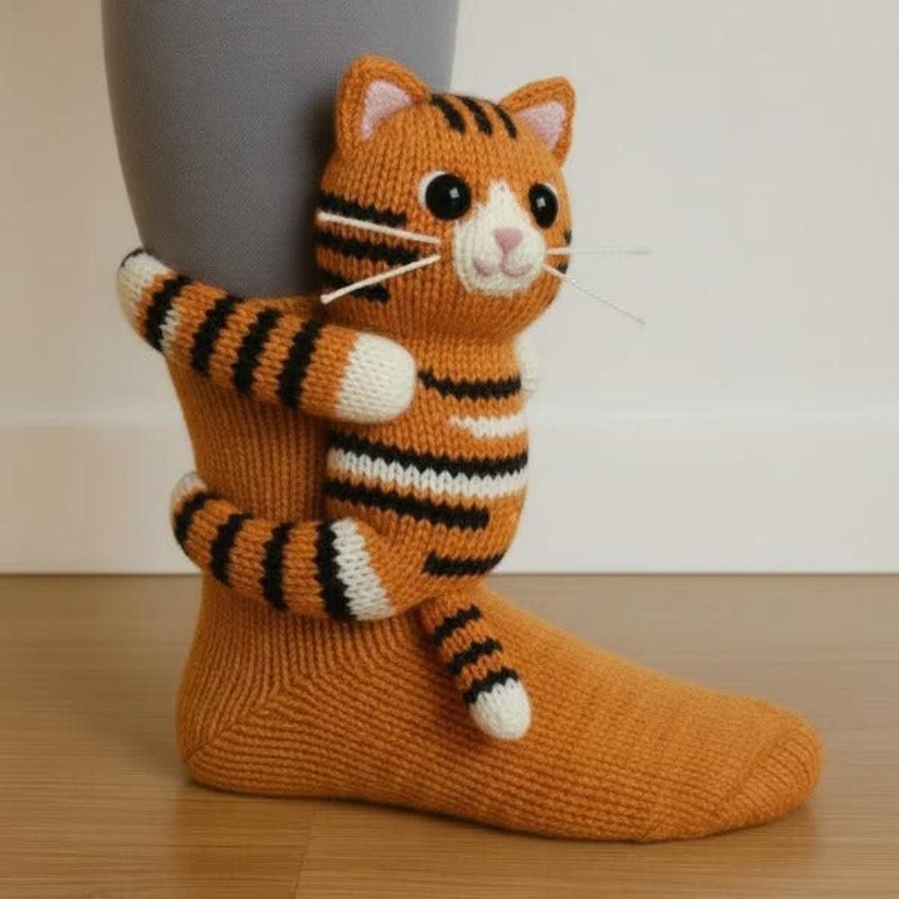 Chaussette orange portée, avec un chat tigré tricoté en 3D aux moustaches blanches enlaçant la jambe 3