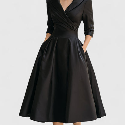 Robe noire cadrée de la taille aux pieds, montrant la jupe ample à plis, la ceinture et les poches. 11
