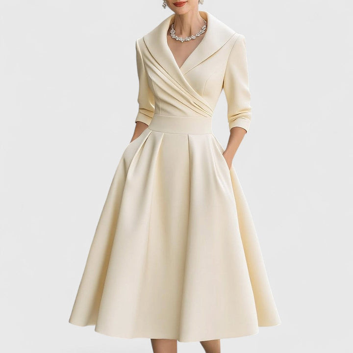 Même robe en beige crème portée de face, buste drapé, ceinture large et jupe trapèze à plis. 4