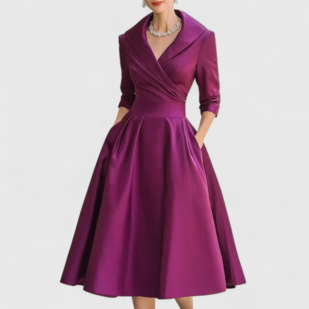 Même robe en violet prune portée de face, col châle, taille marquée et jupe évasée mi-longue. 5